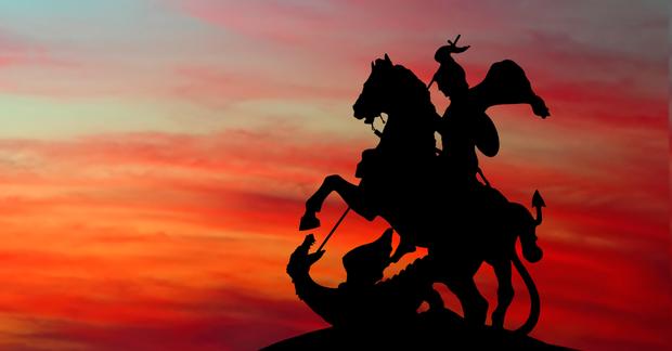 silhouette of George and the Dragon statue, Moscow, in front of a sunset sky