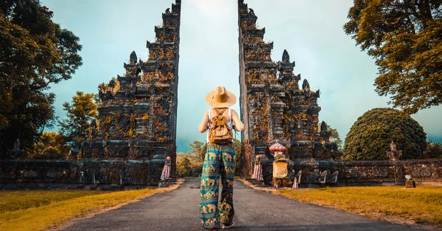 woman walking down a path through an historic gate in Bali, Indonesia